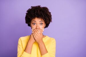 woman holding her hands over her mouth covering bad breath dentist in Palmdale California